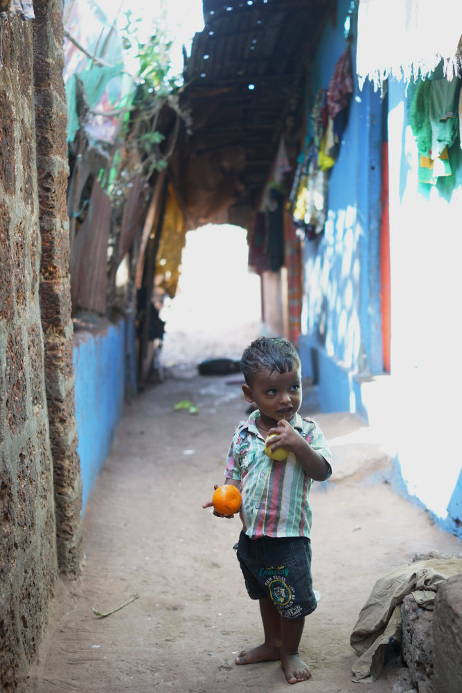 Boy Standing In Passage With Fruit