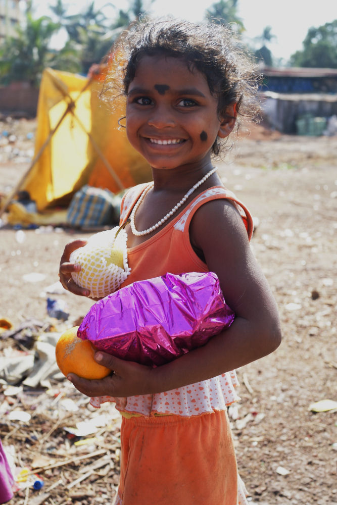 Young Girl Holding Christmas Presents And Fruit