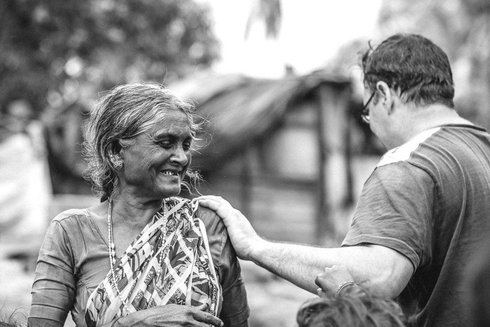 Black And White Photo Of Slum Lady And Rob Smiling