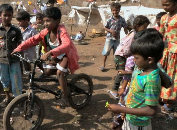 The children riding the BMX bike through the slums in Goa