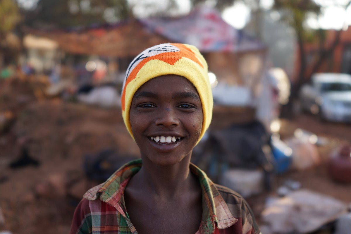 Migrant Boy Smiling With New Hat