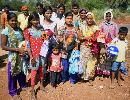 A group of roadworkers and their children receiving gifts
