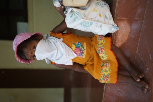 One of the girls with a donated pink hat that she can take home along with lots of other goodies.