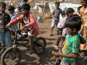 The children riding the BMX bike through the slums in Goa